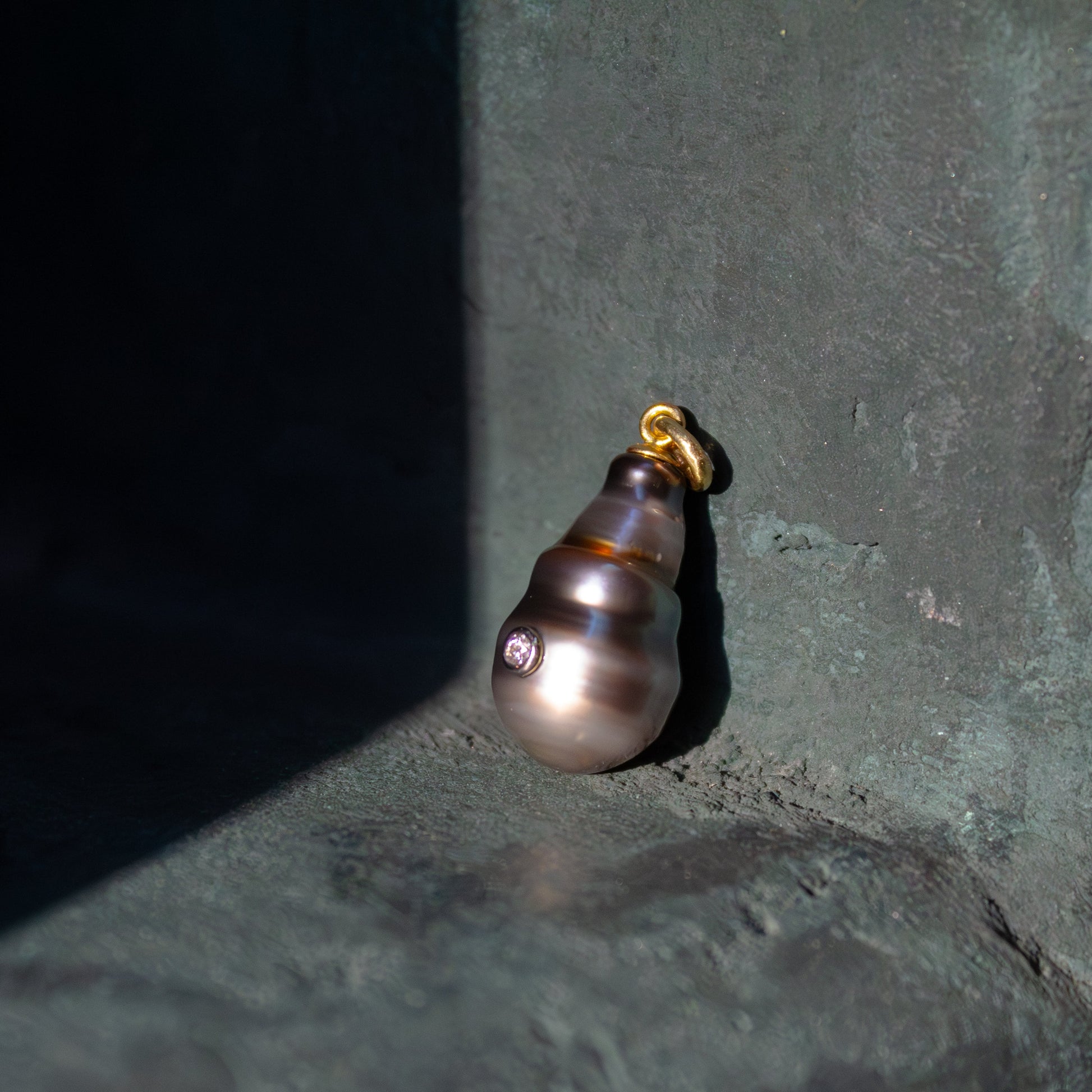 Pearl earring on a dark textured surface